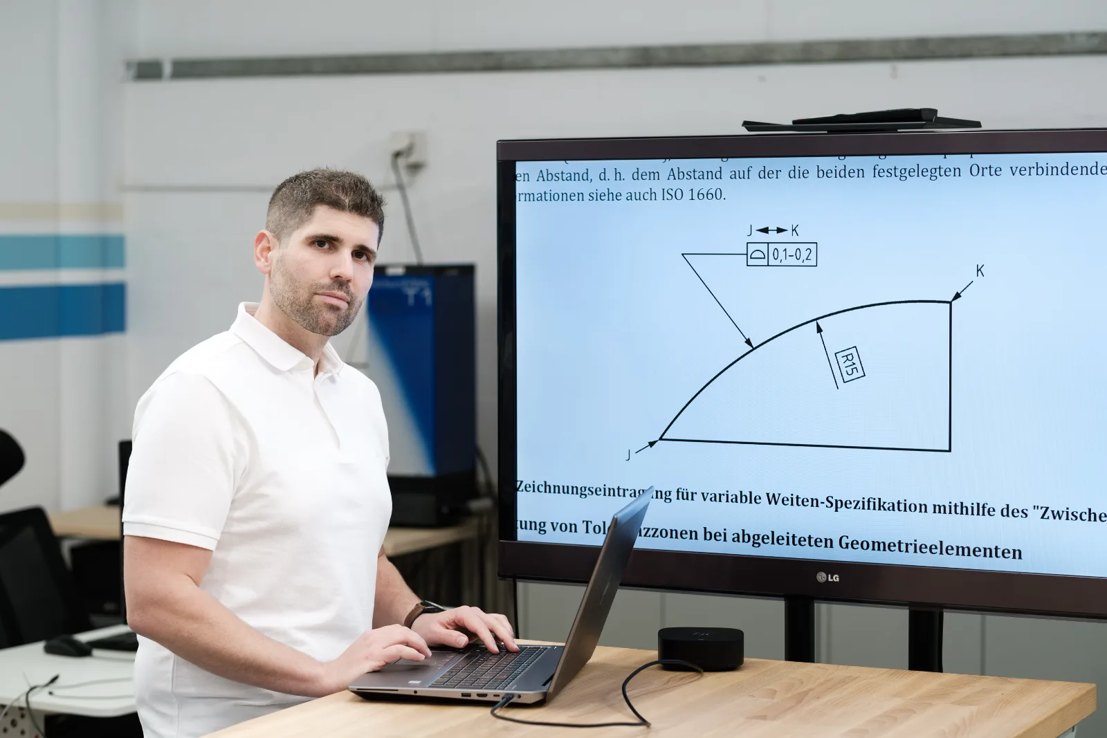 ISO GPS consulting: Christian Schärer discussing a drawing indication for a variable width specification on a large screen