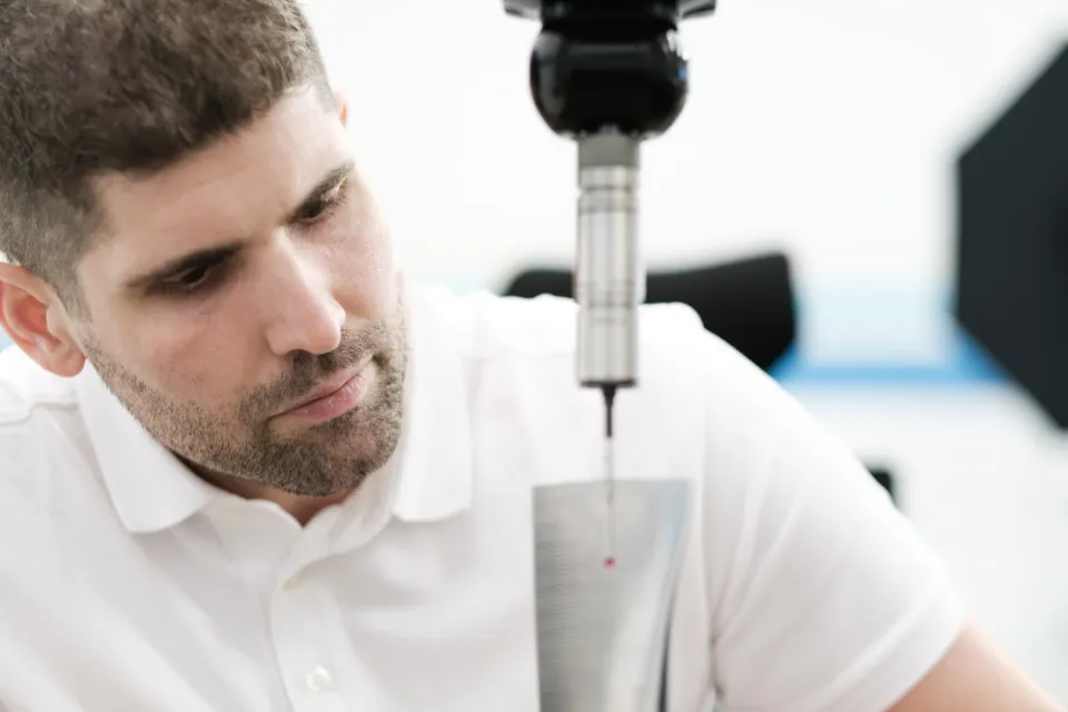 Metrologist checking the stylus on a coordinate measuring machine in the measuring laboratory